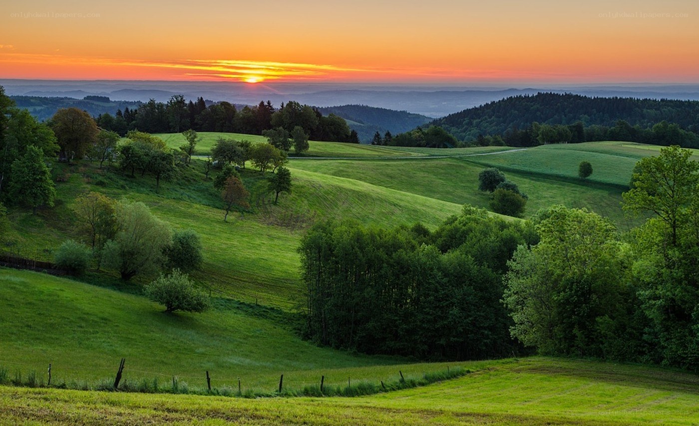 Sunset over rolling green hills