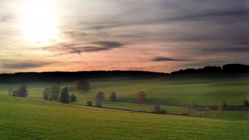 Sunset over rolling green hills