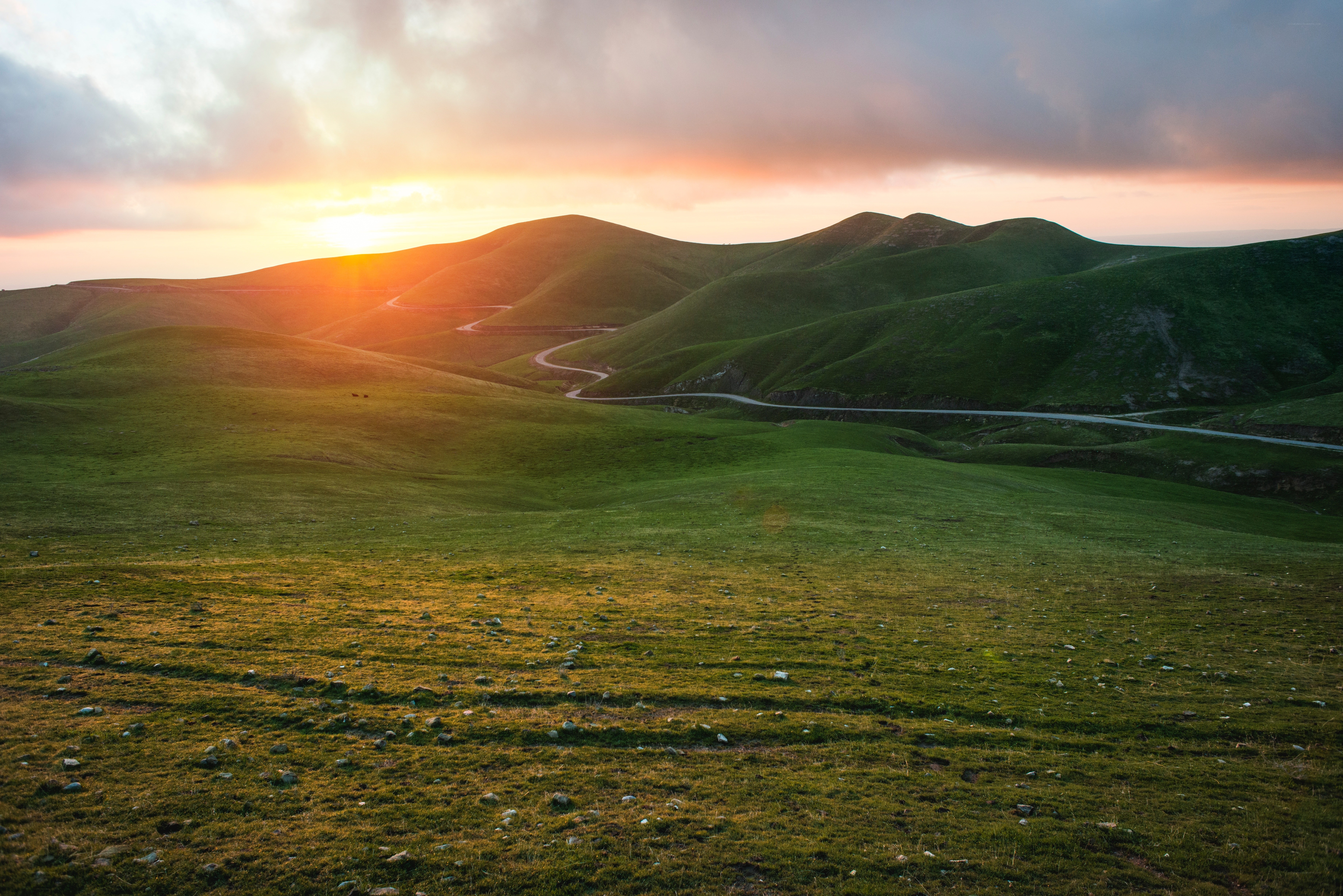 Sunset over rolling green hills