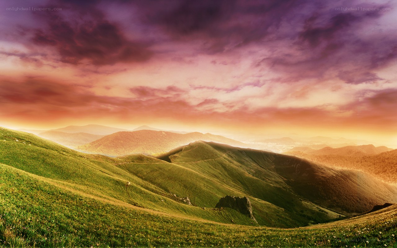 Sunset over rolling green hills