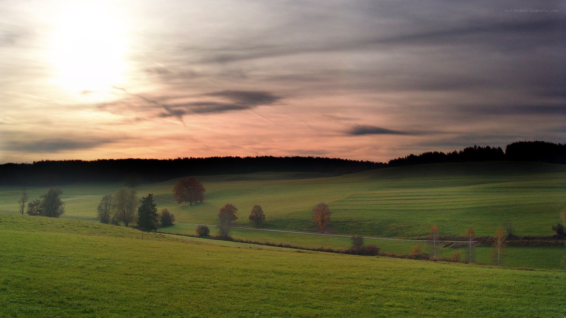 Sunset over rolling green hills