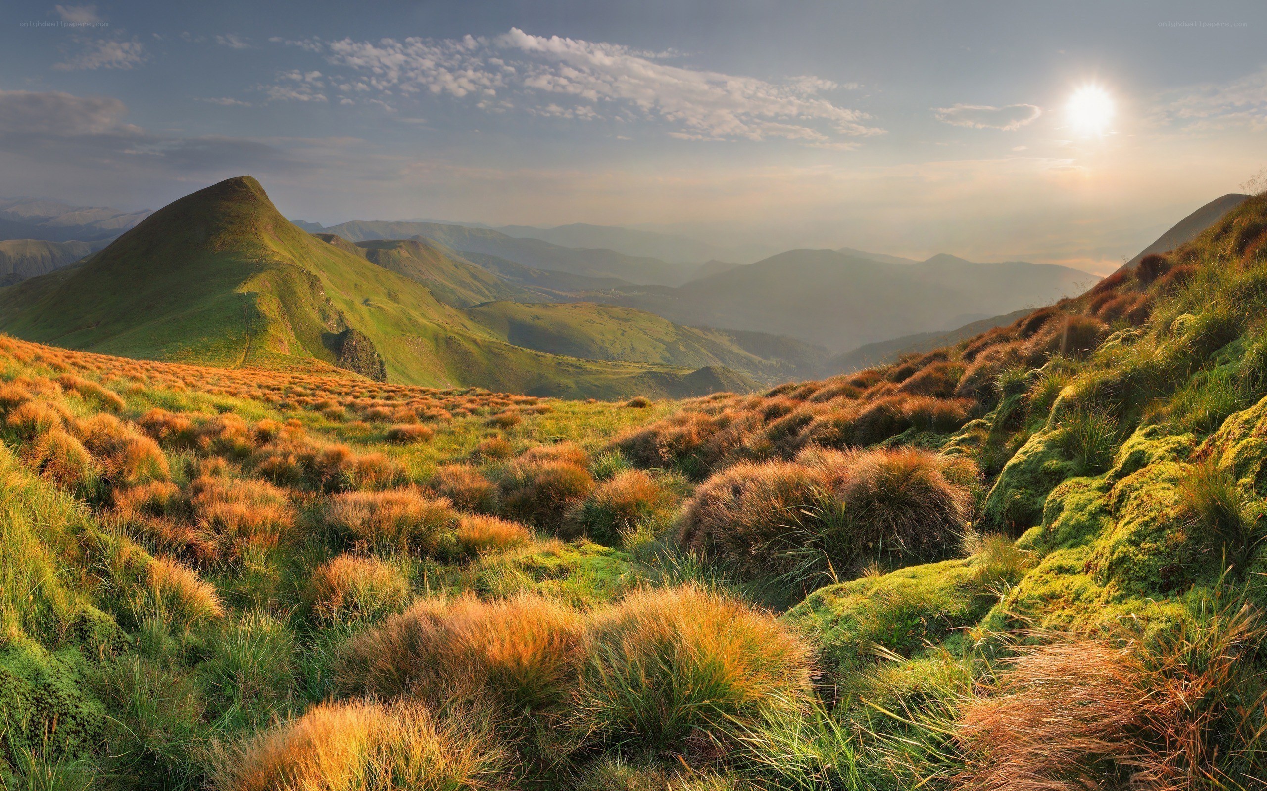 Sunset over rolling green hills