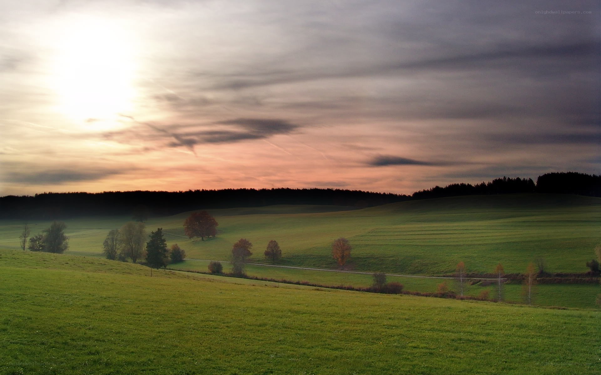 Sunset over rolling green hills