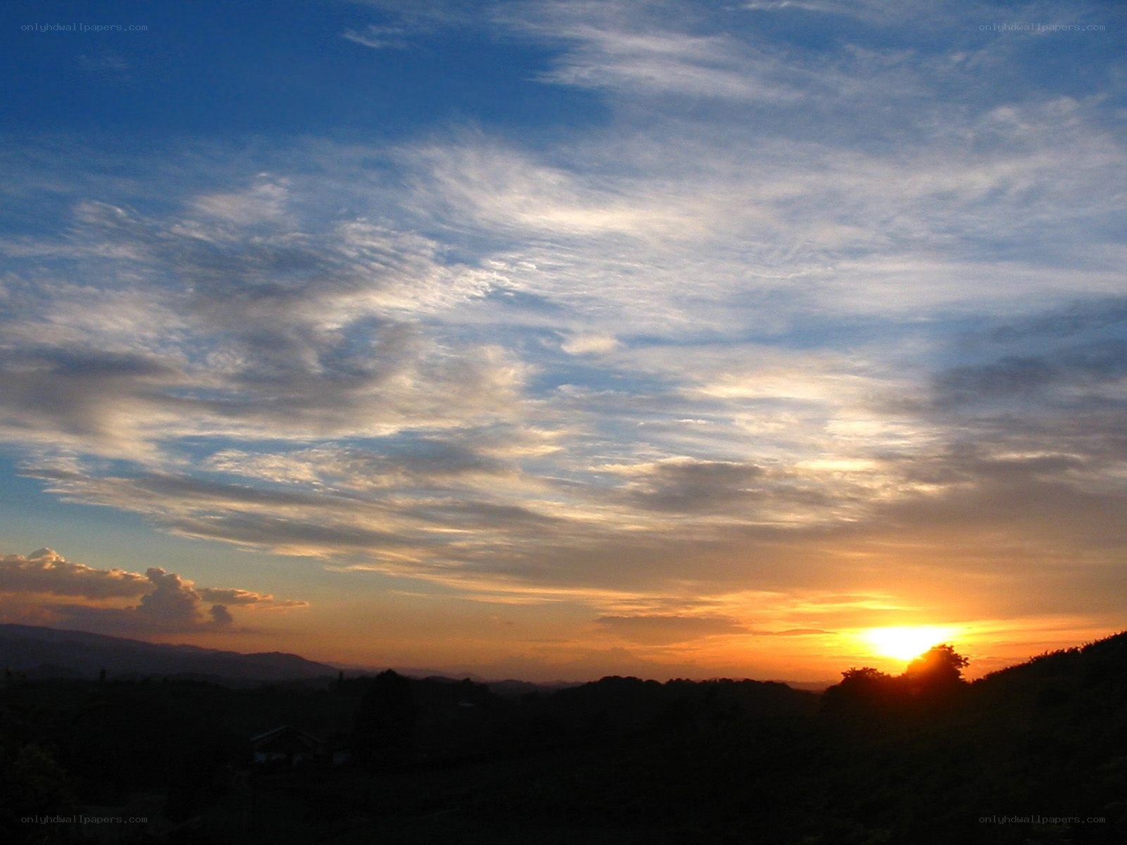 sunset over rolling hills