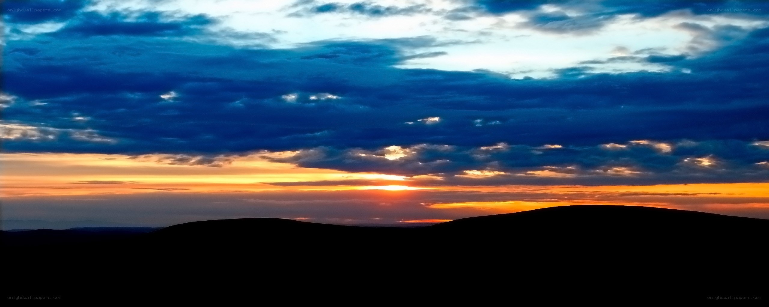 sunset over rolling hills