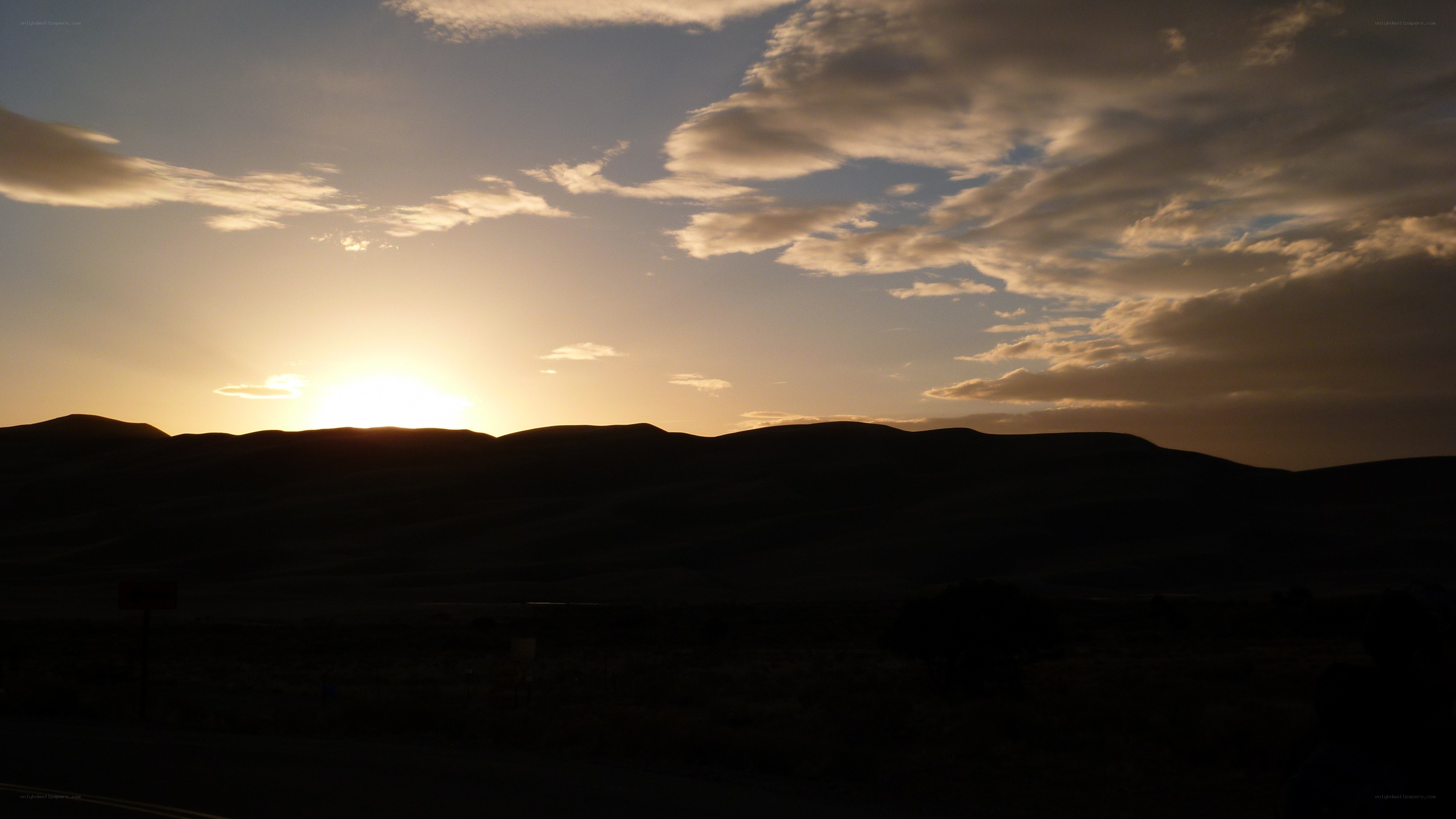 sunset over rolling hills