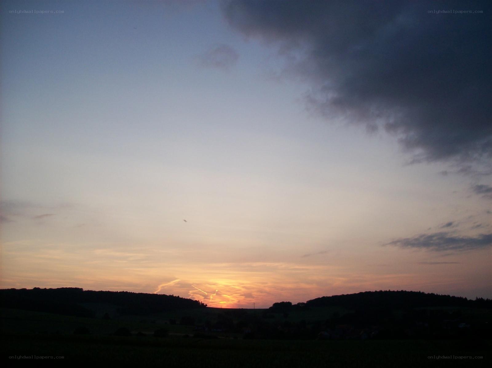 sunset over rolling hills