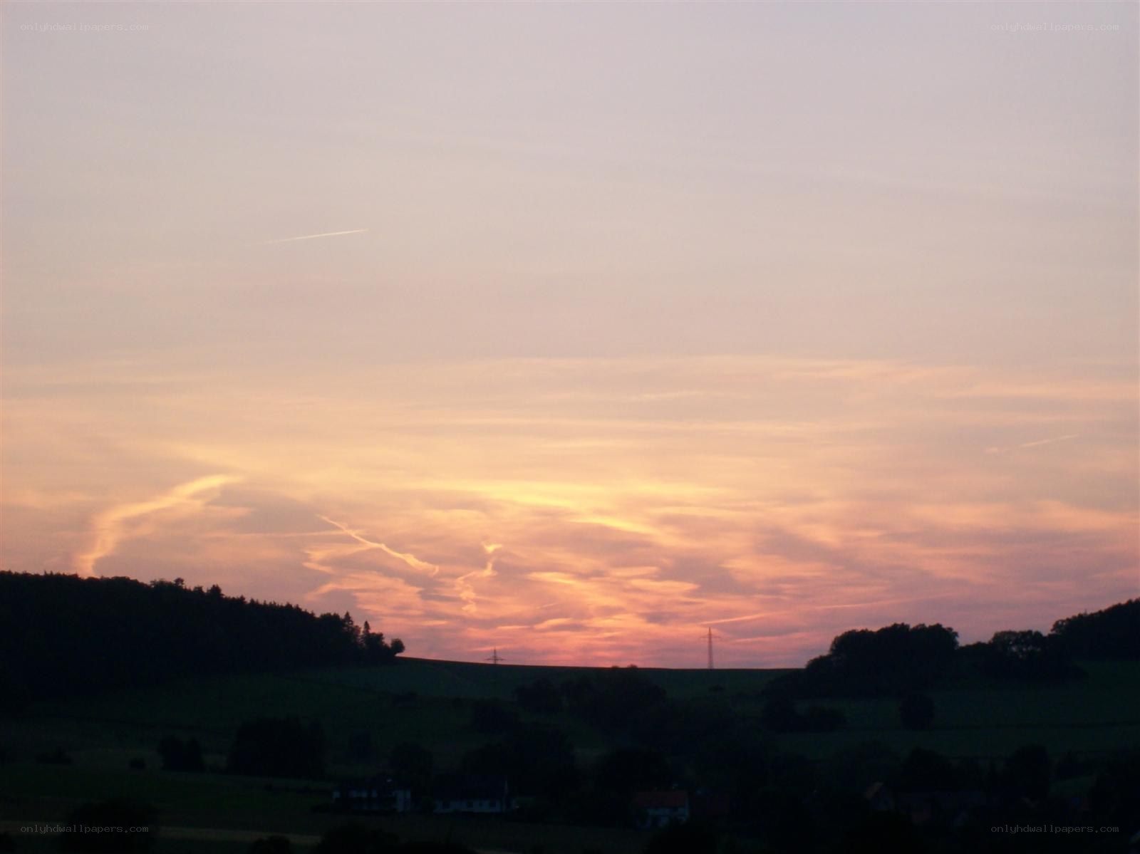 sunset over rolling hills