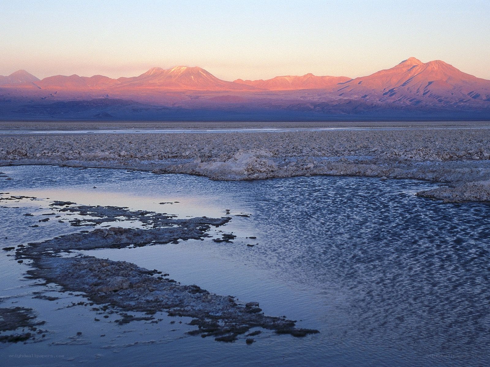sunset over salt flats and mountains