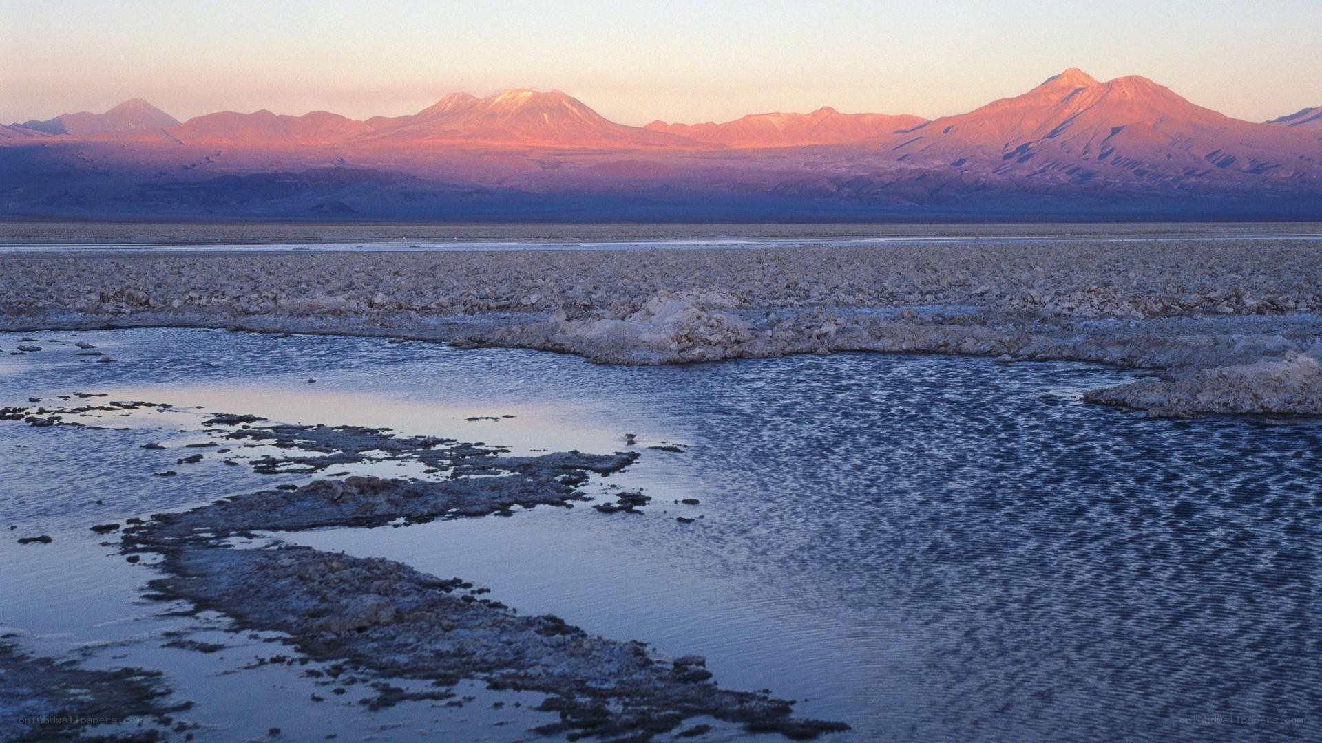 sunset over salt flats and mountains