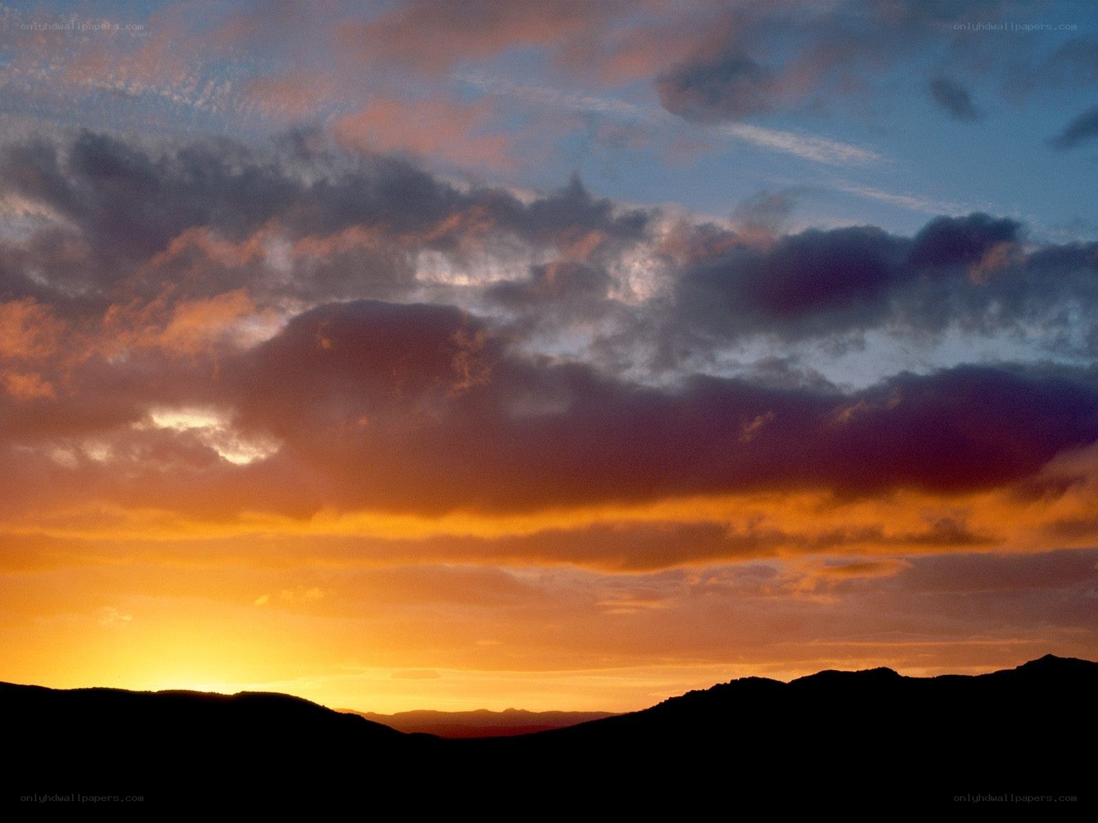 Sunset over silhouetted hills