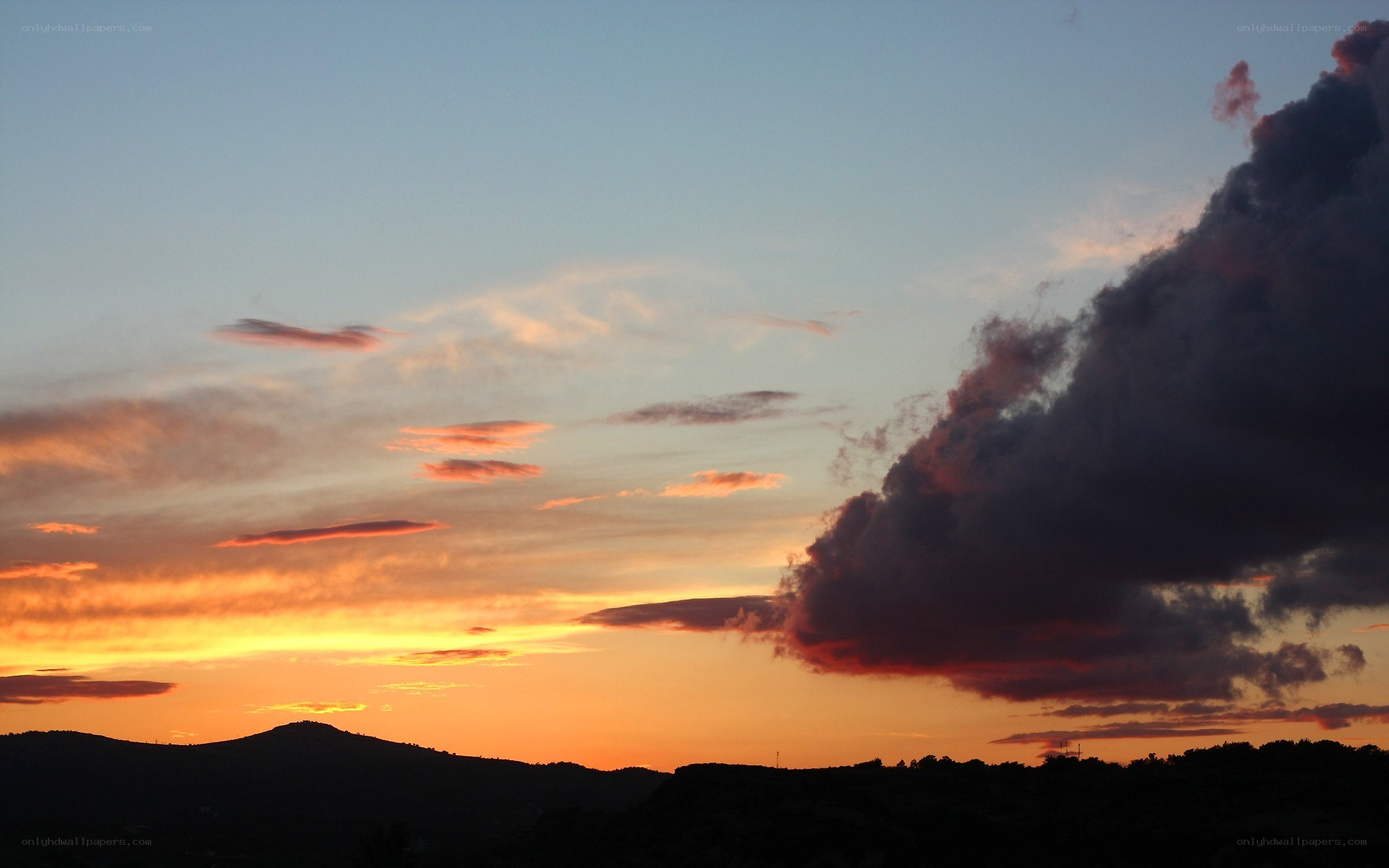 sunset over silhouetted hills