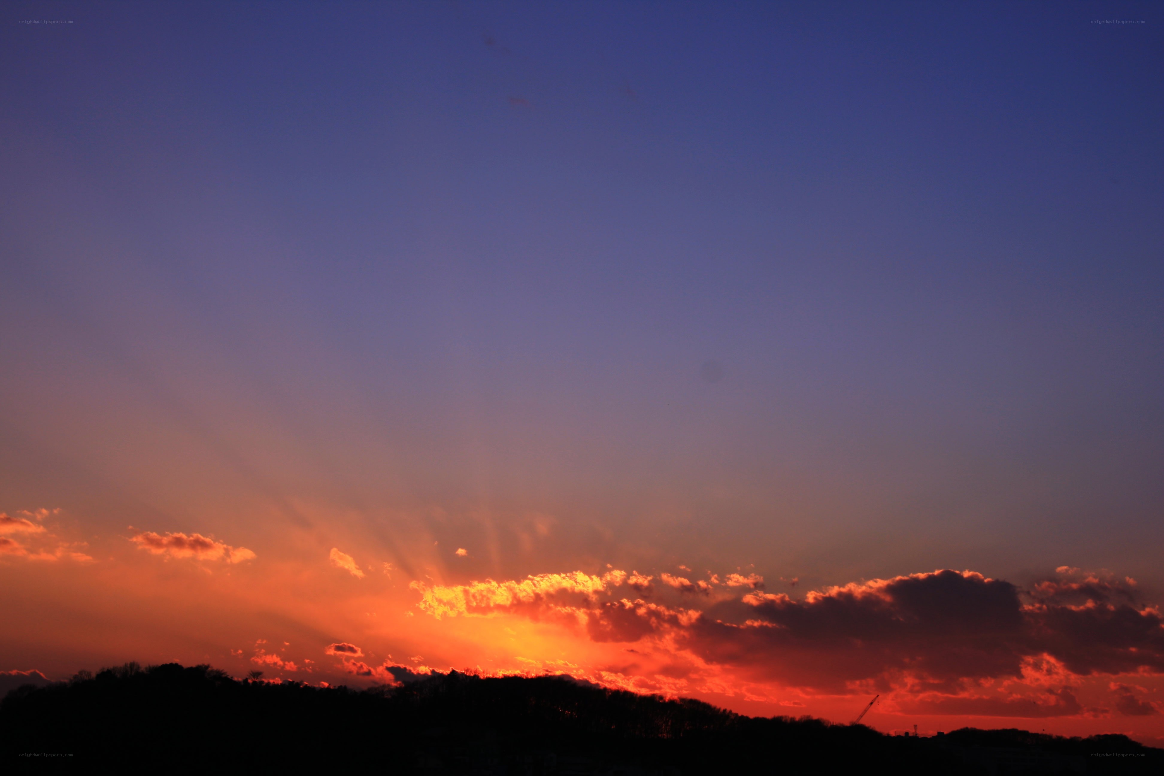 sunset over silhouetted hills