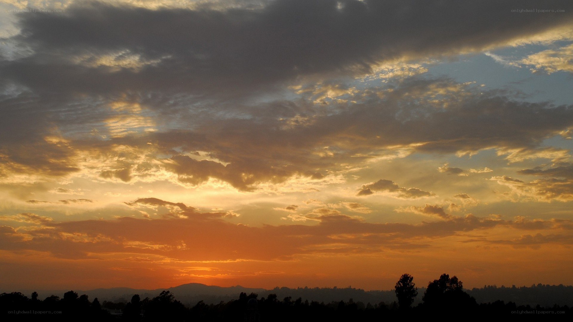 sunset over silhouetted hills