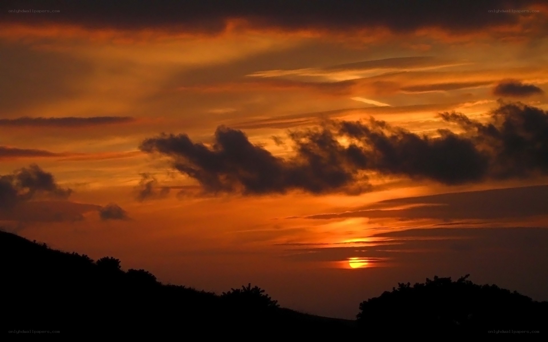 Sunset over silhouetted hills