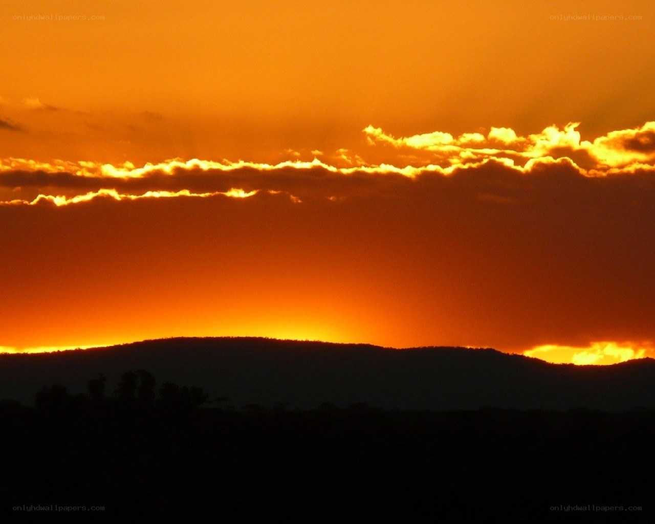 Sunset over silhouetted hills