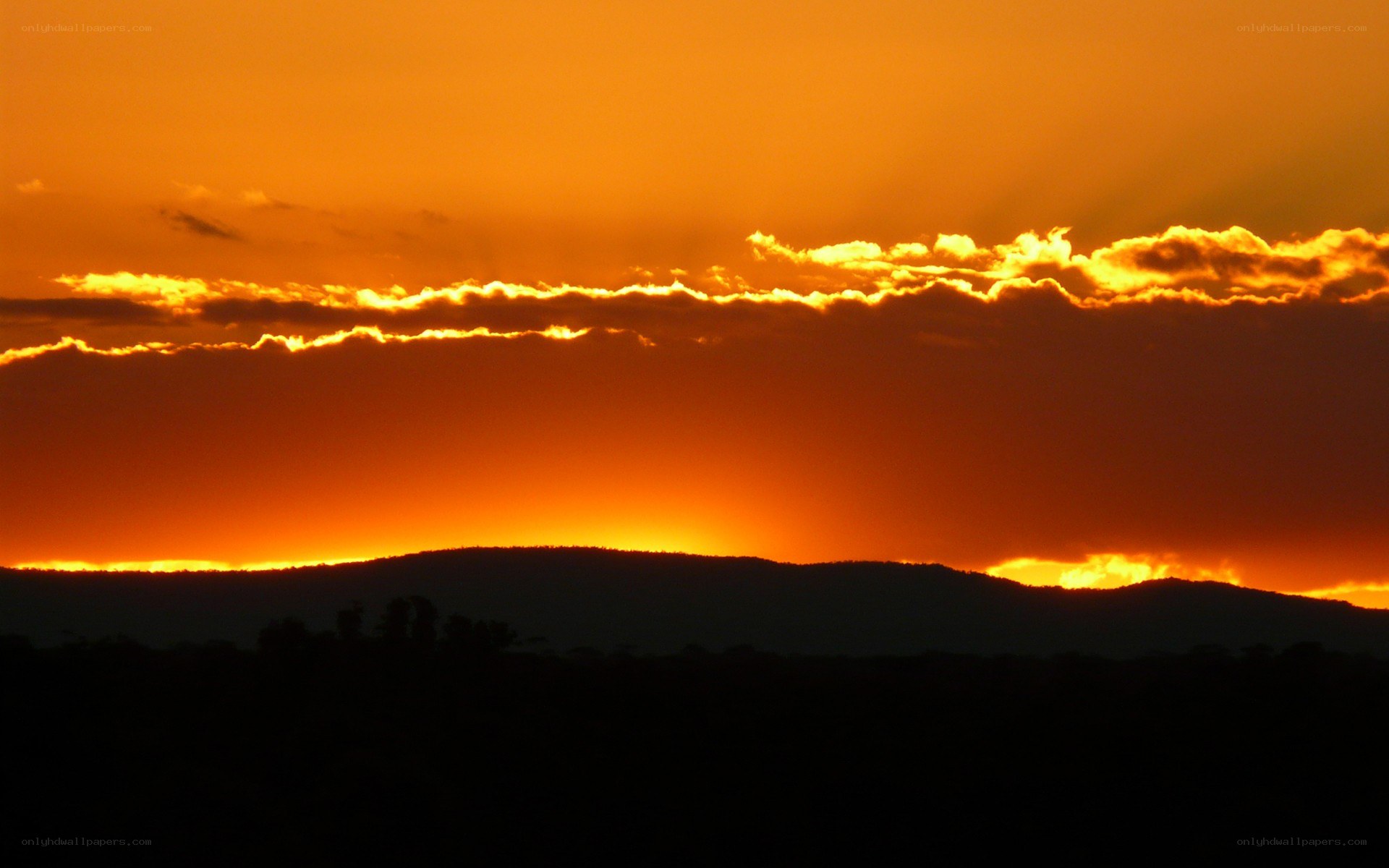 Sunset over silhouetted hills
