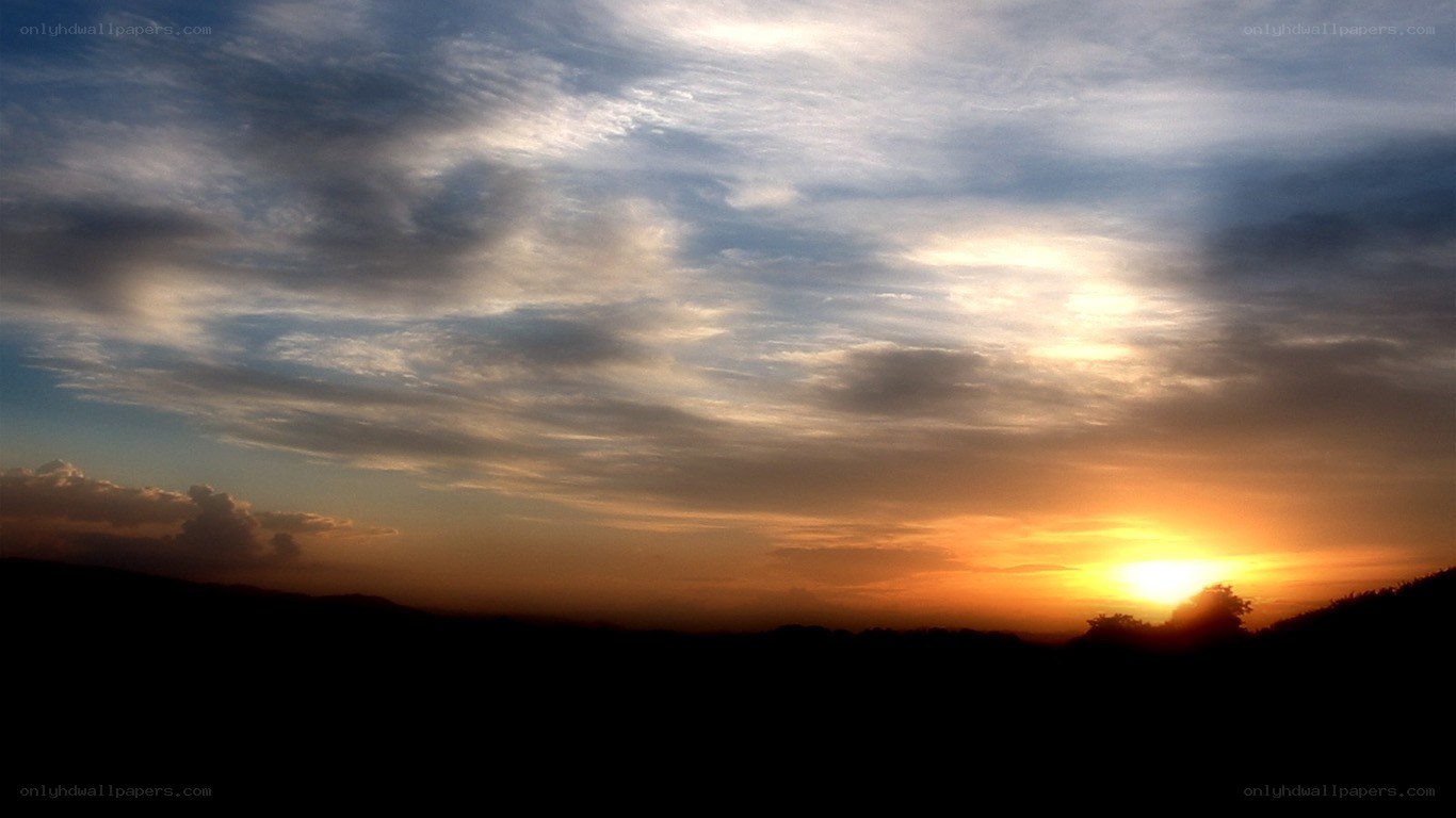 sunset over silhouetted hills