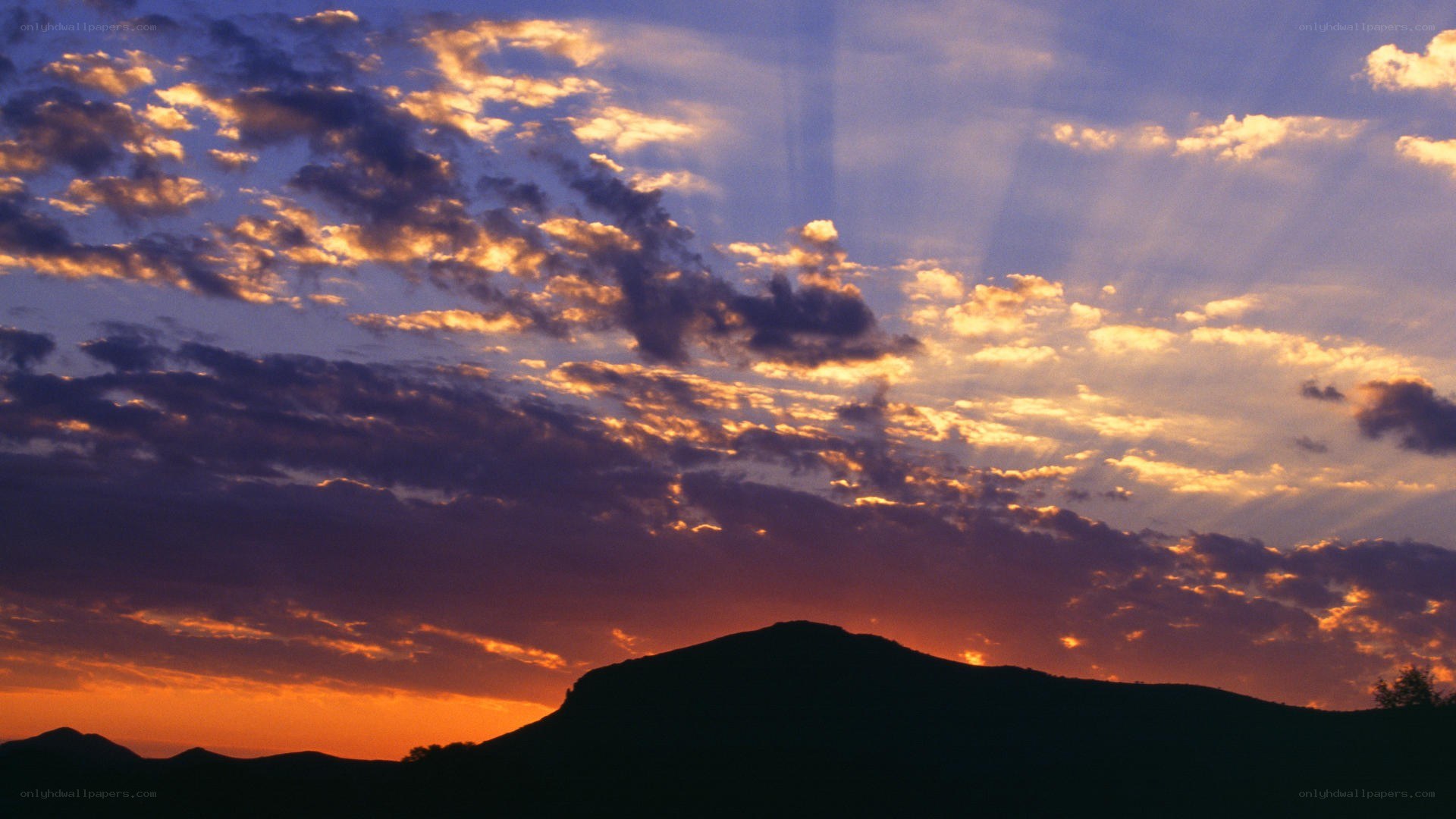sunset over silhouetted hills