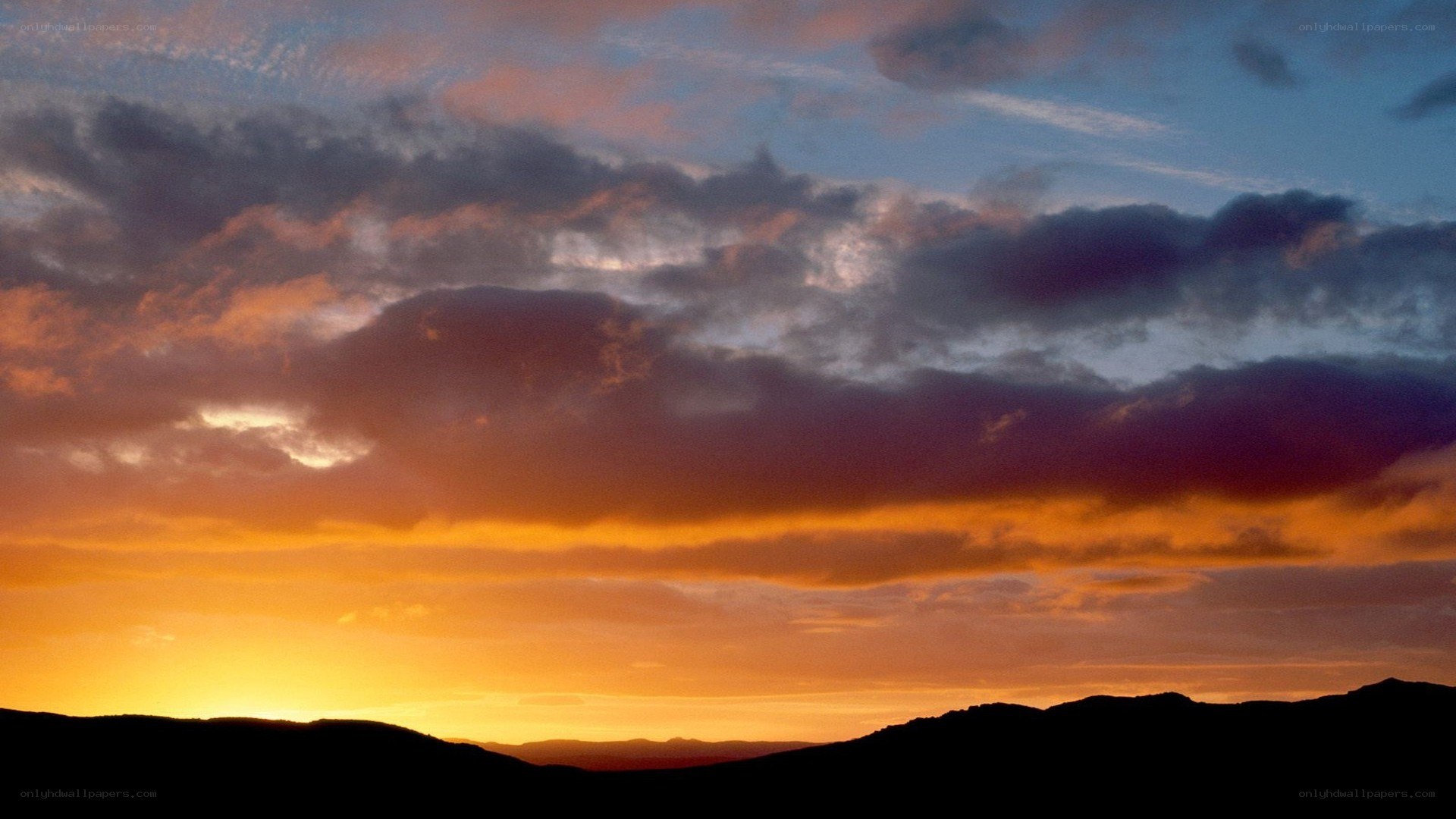 sunset over silhouetted hills