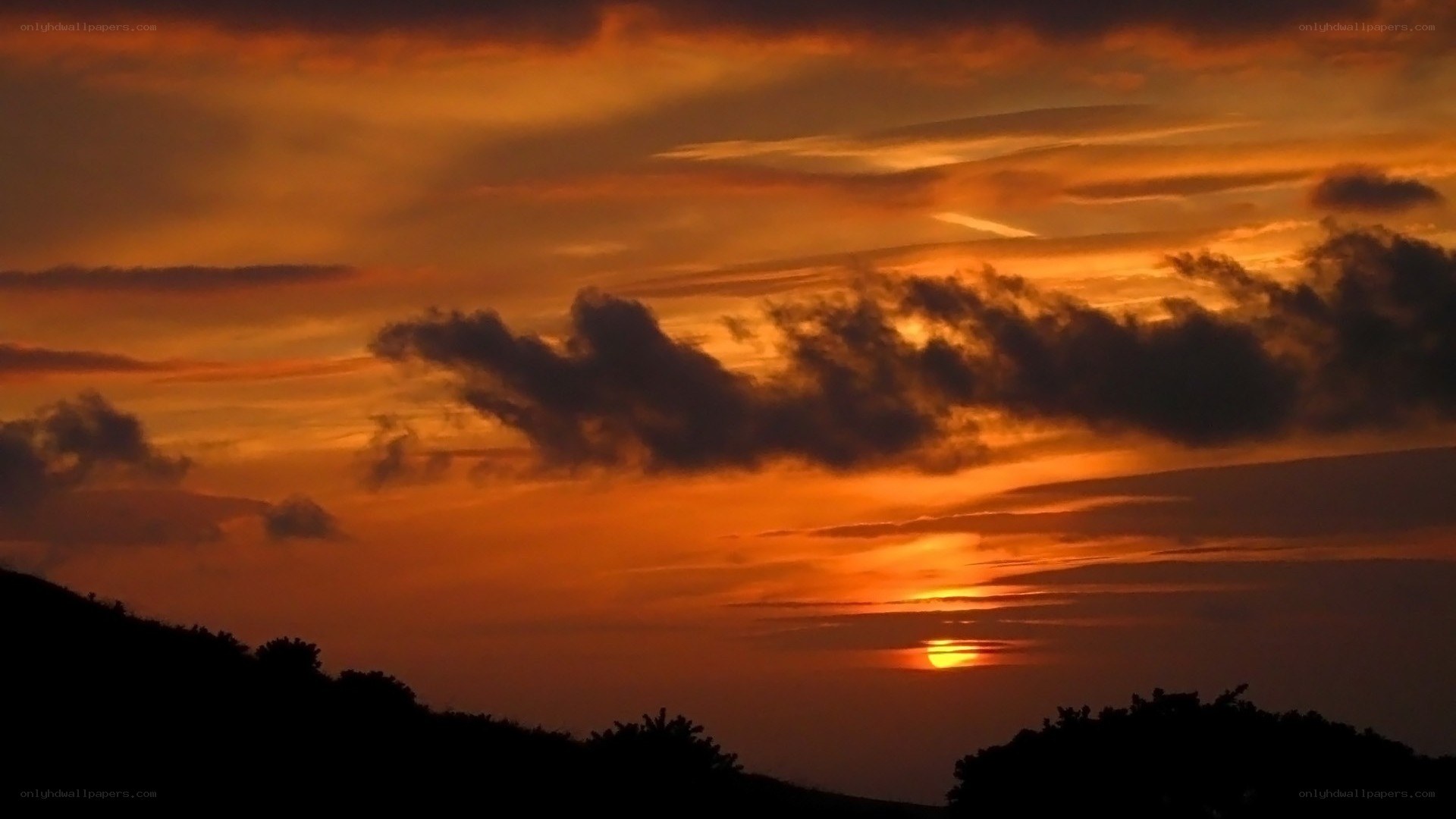 Sunset over silhouetted hills