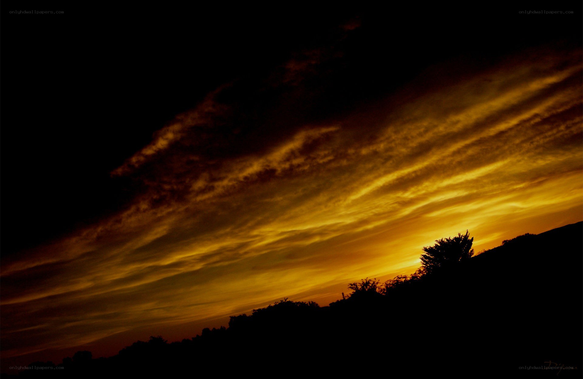 sunset over silhouetted hills
