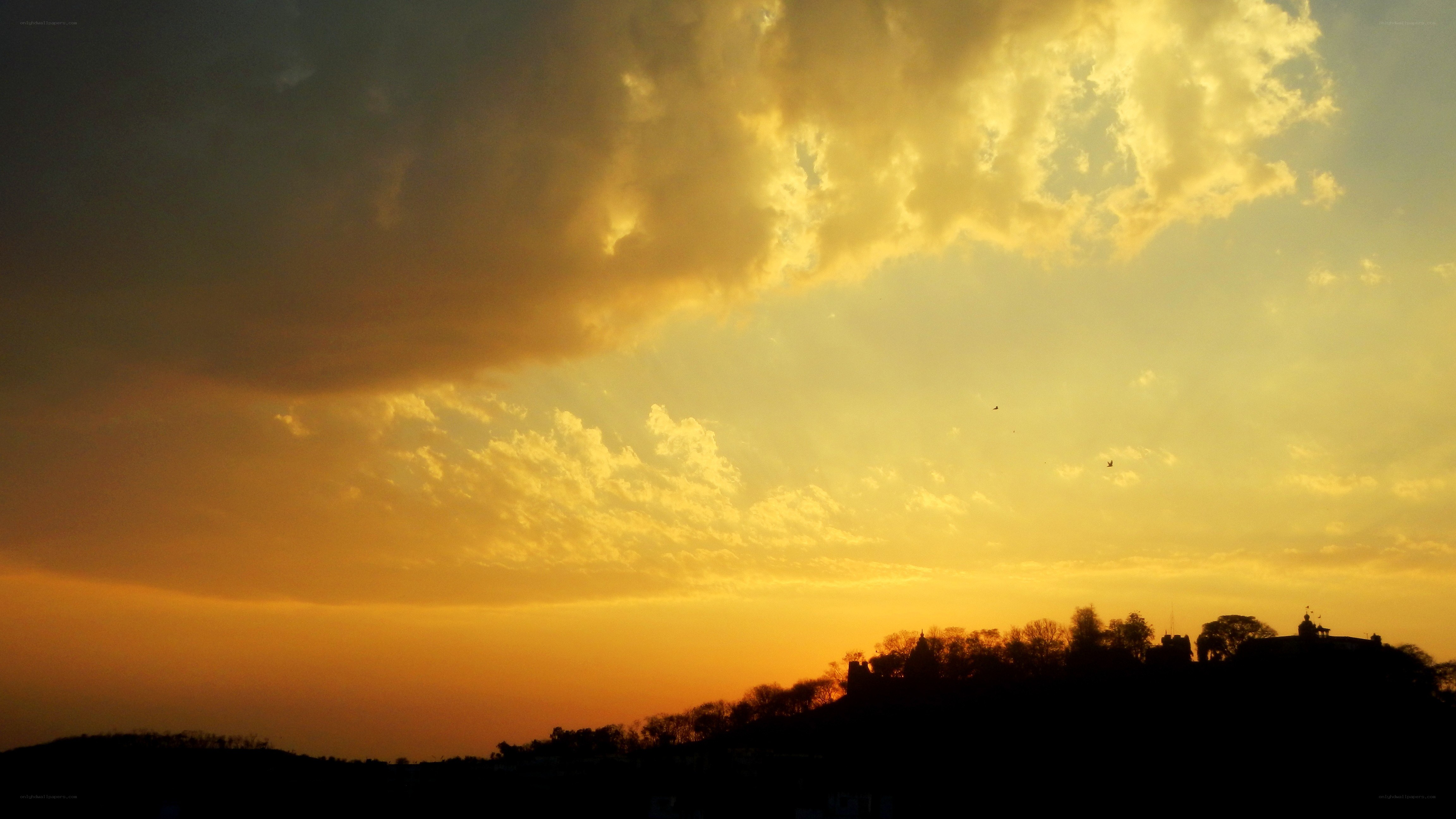 sunset over silhouetted hills