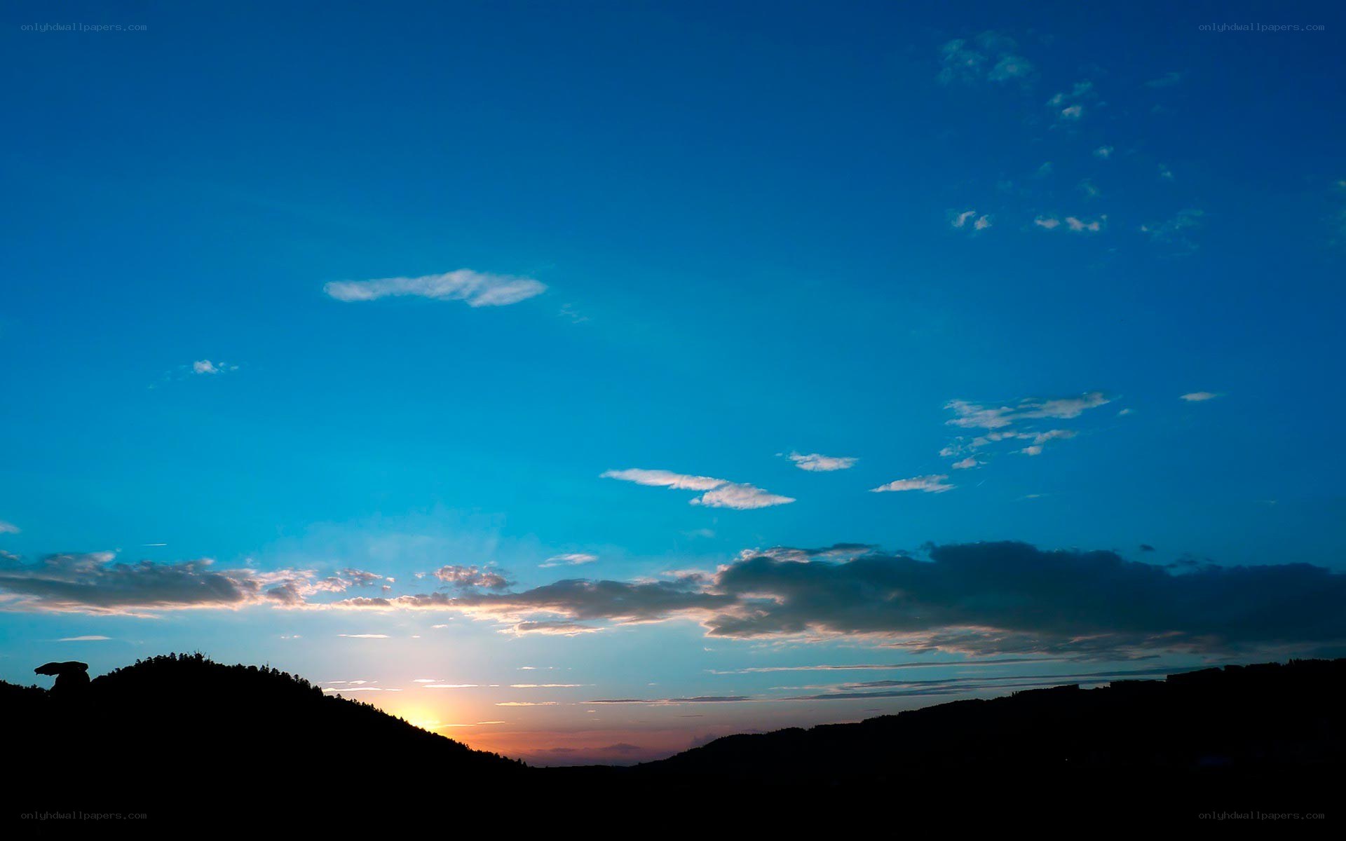Sunset over silhouetted hills