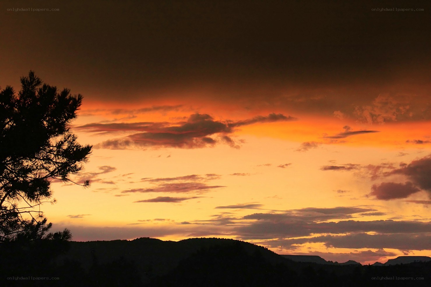 sunset over silhouetted hills