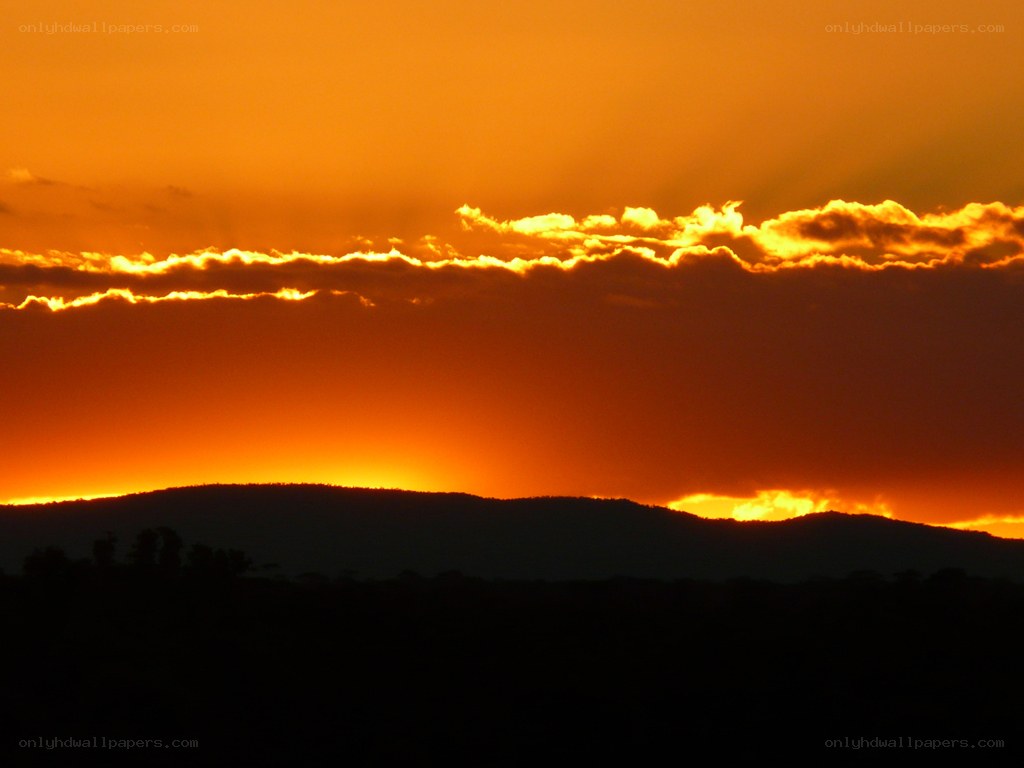 sunset over silhouetted hills