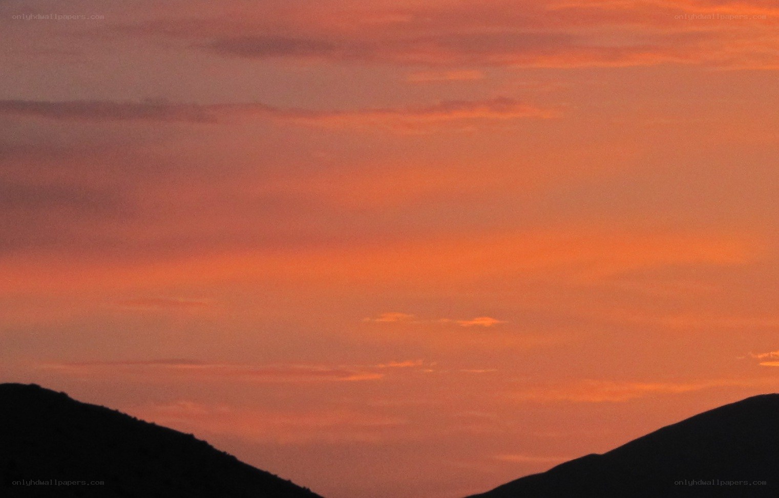 sunset over silhouetted hills