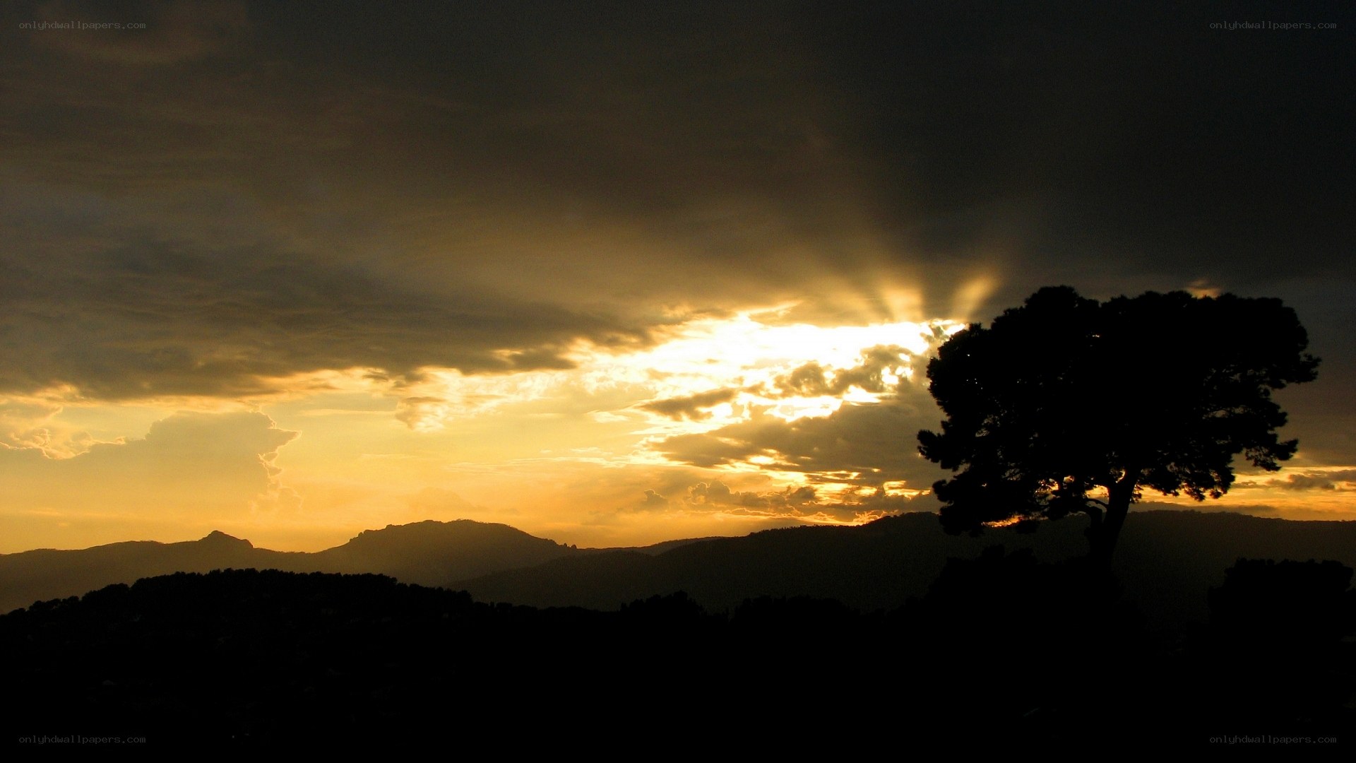 sunset over silhouetted hills