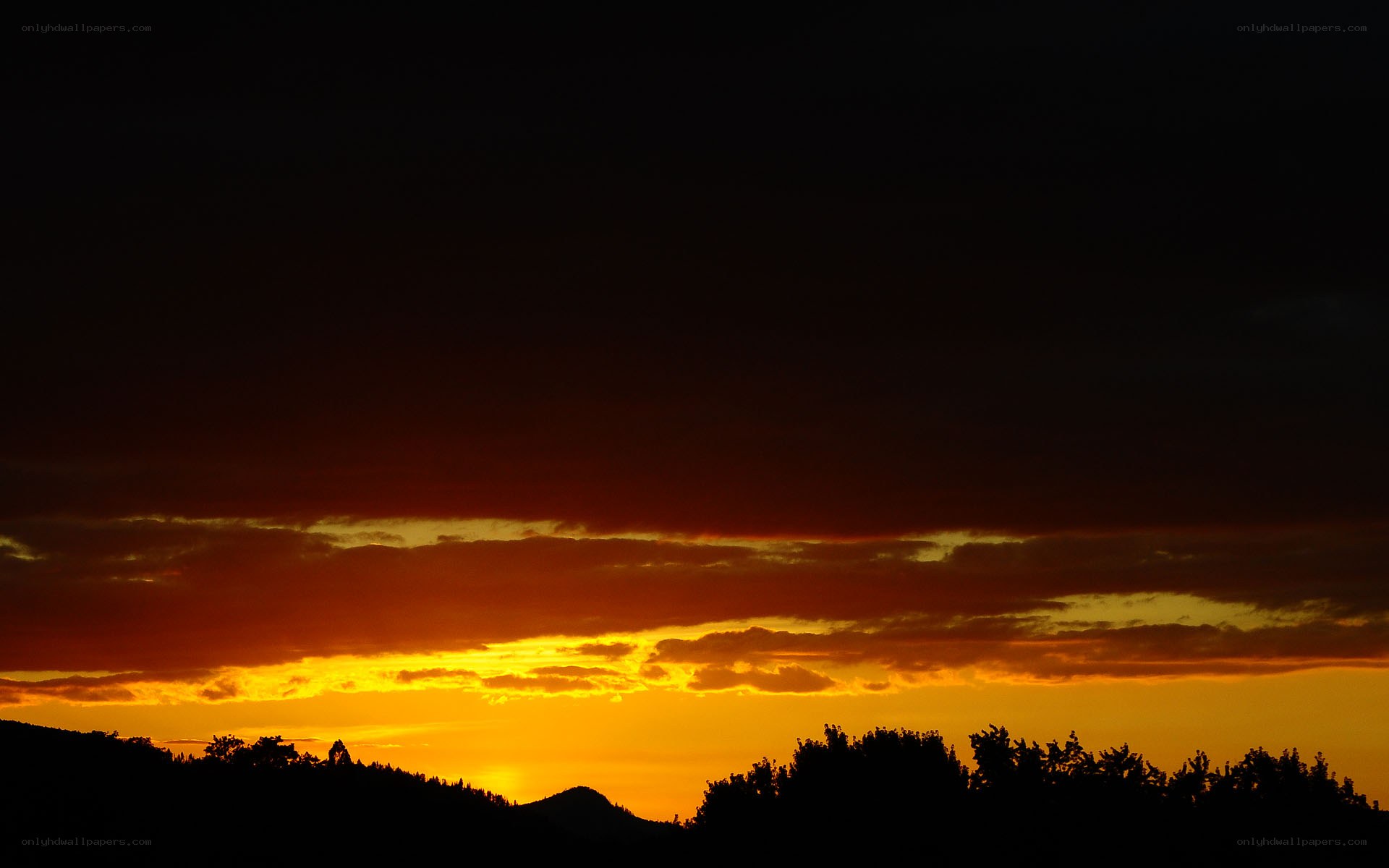 sunset over silhouetted hills