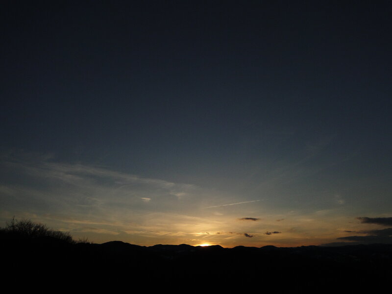 Sunset over silhouetted hills
