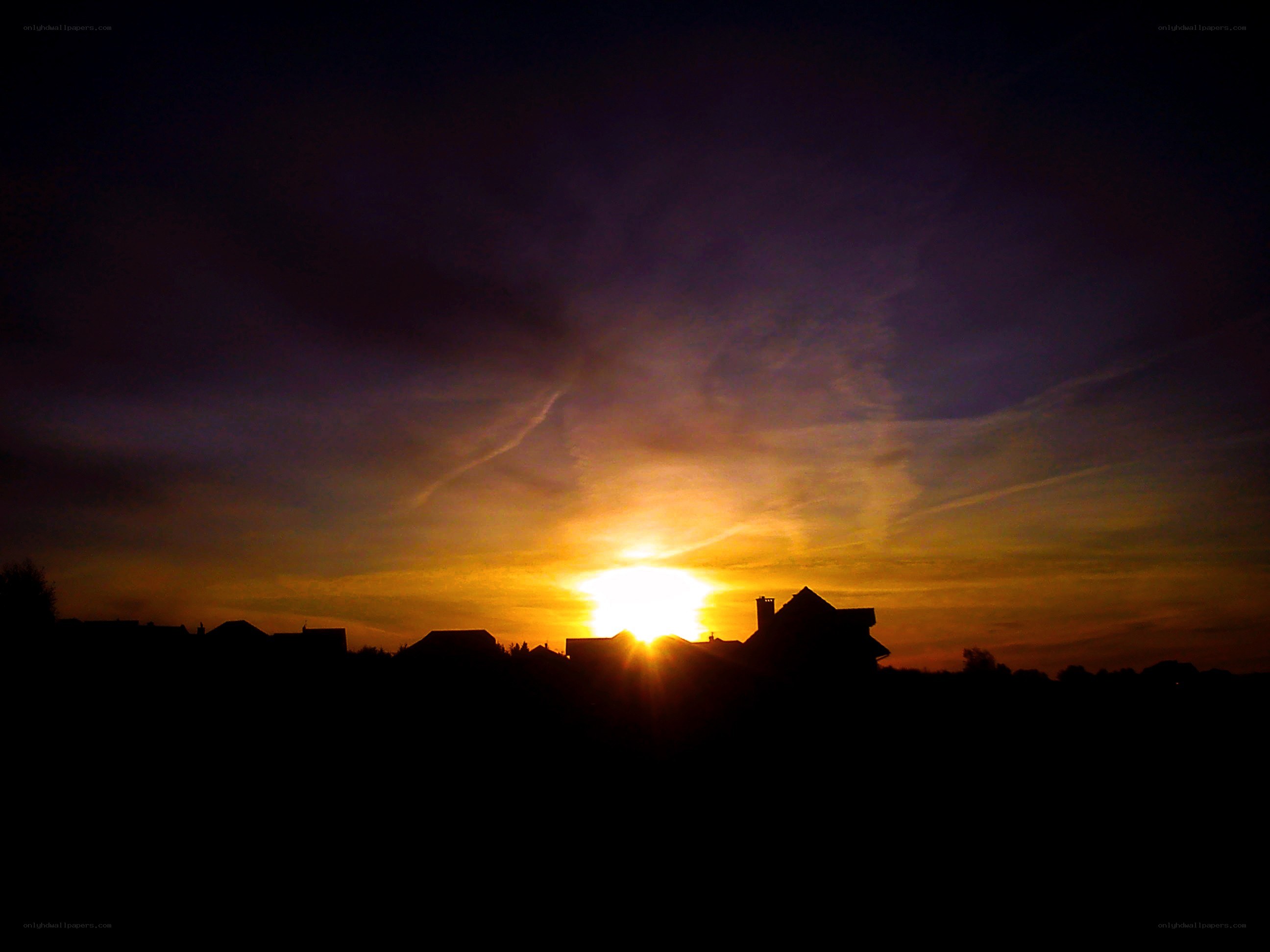 Sunset over silhouetted houses