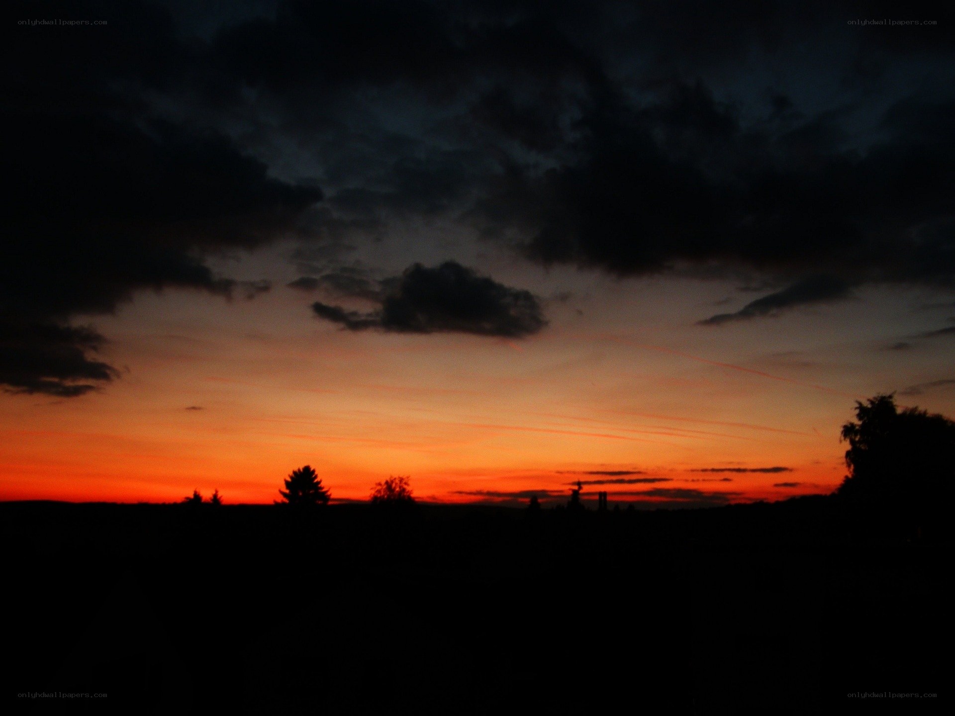 sunset over silhouetted landscape