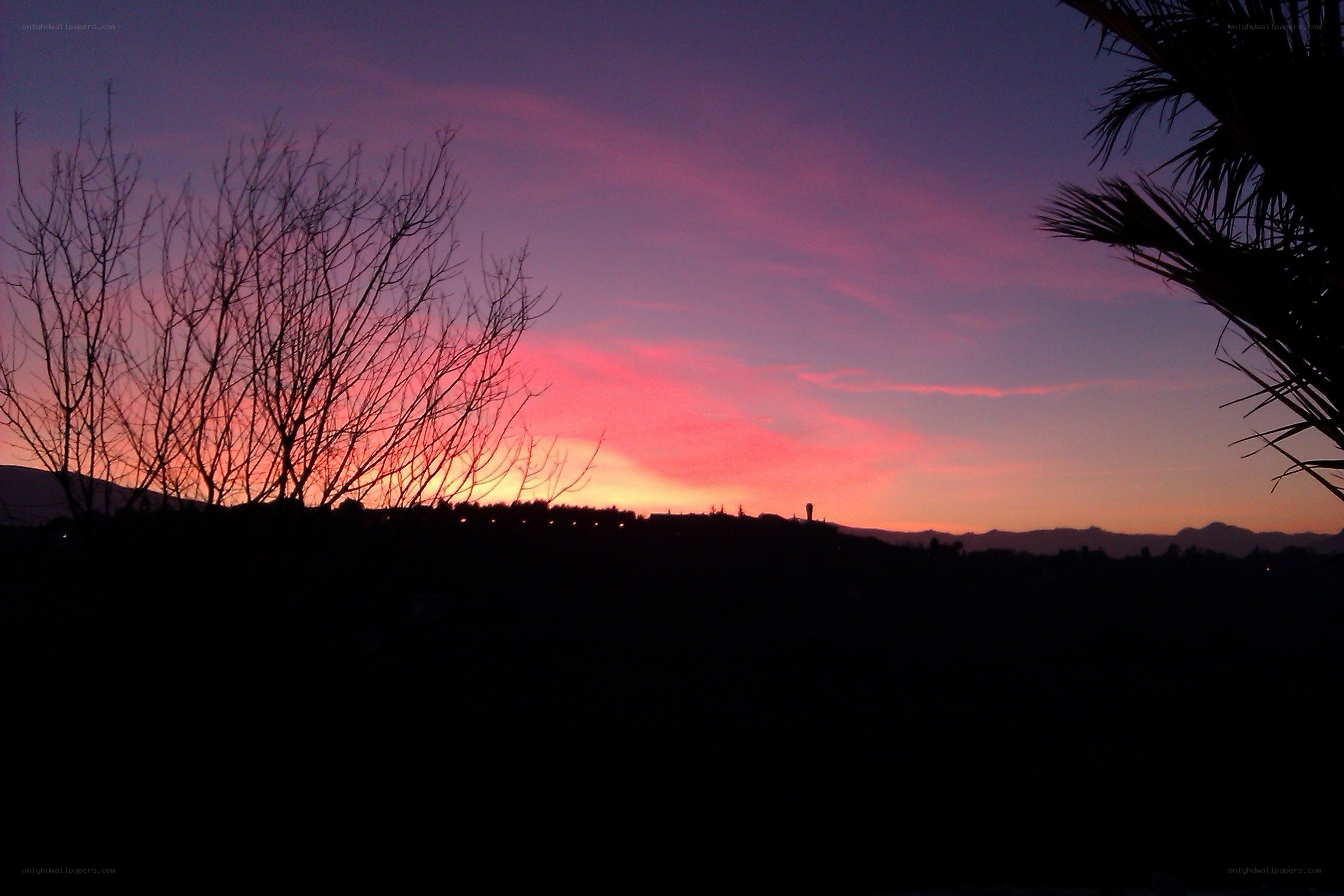 sunset over silhouetted landscape