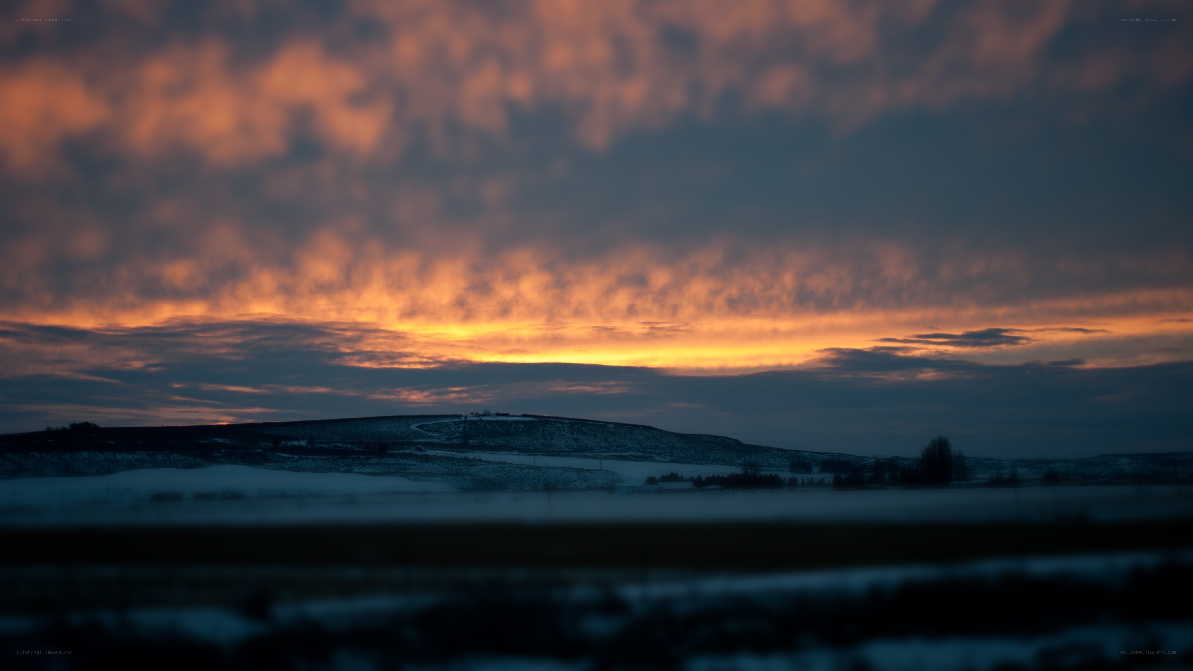 sunset over snowy hills