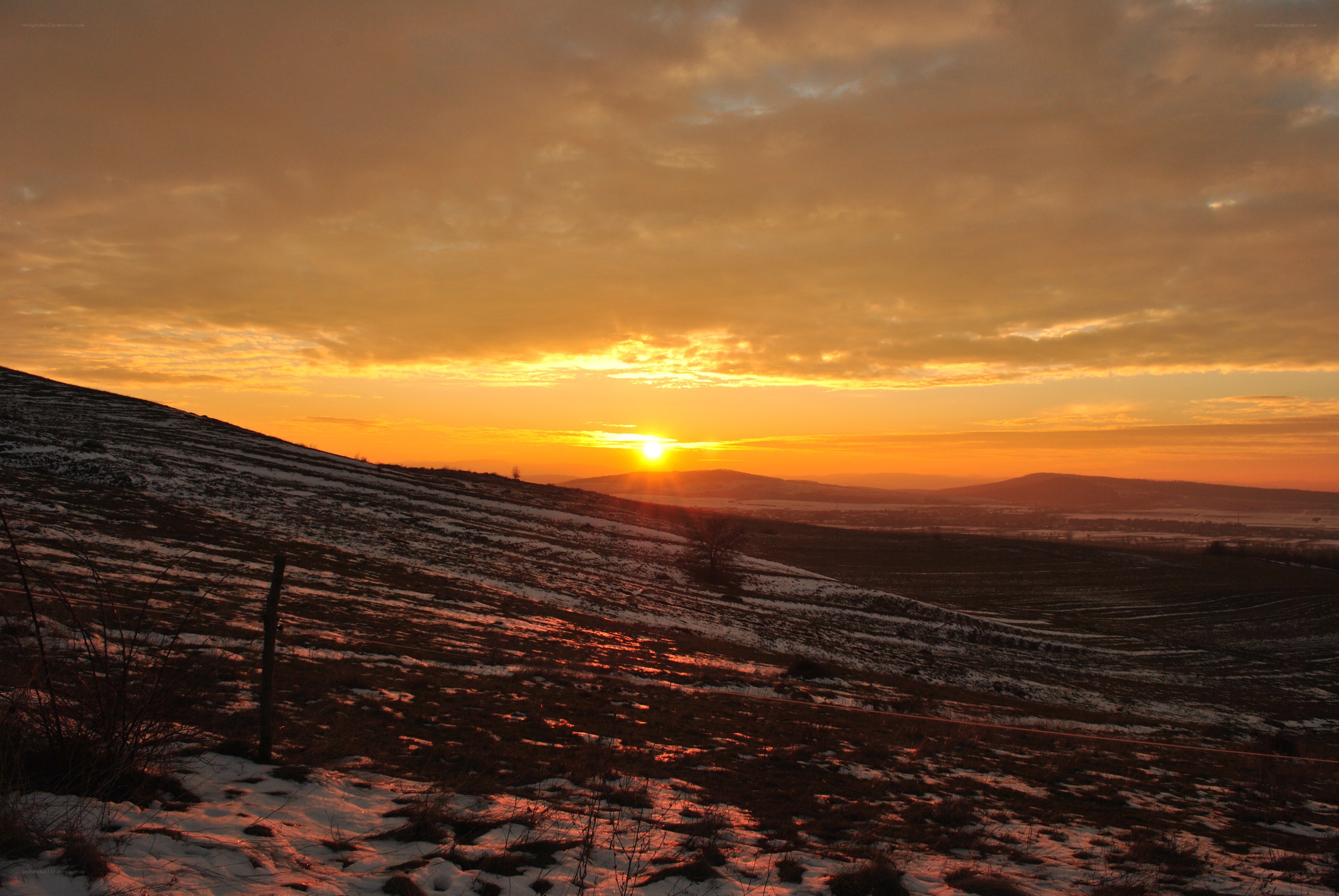 Sunset over snowy hills
