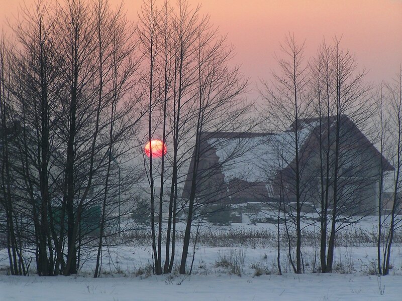 Sunset over snowy house