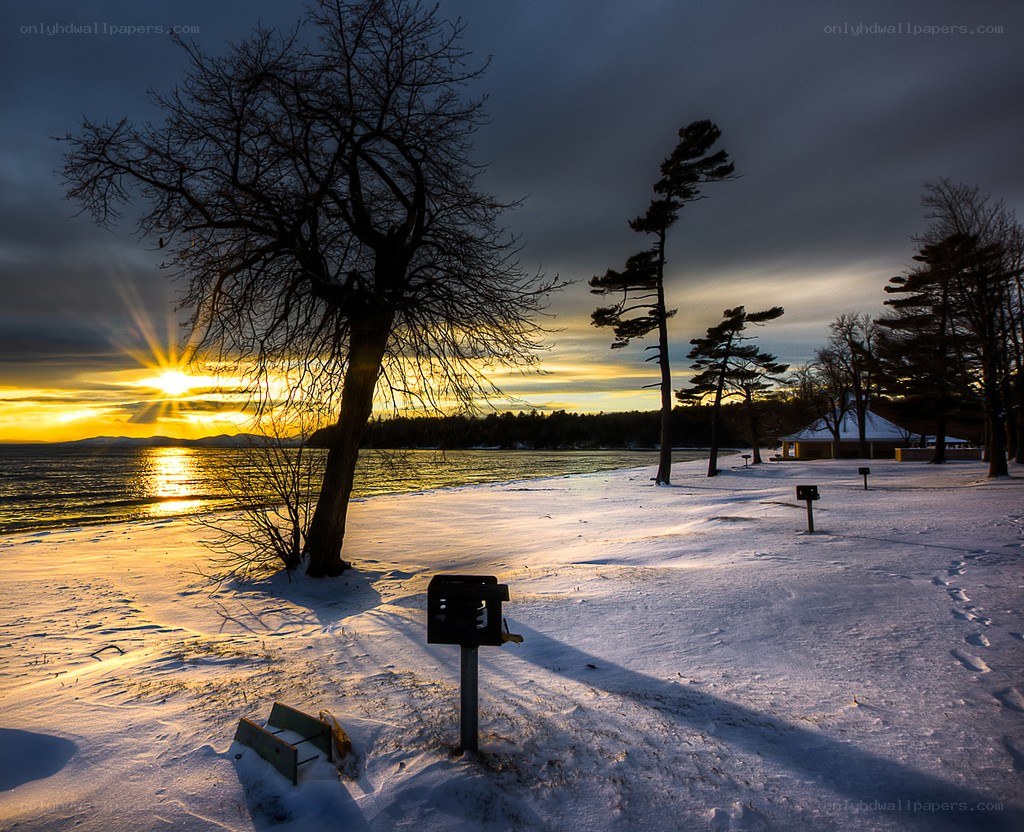 Sunset over snowy lake shore