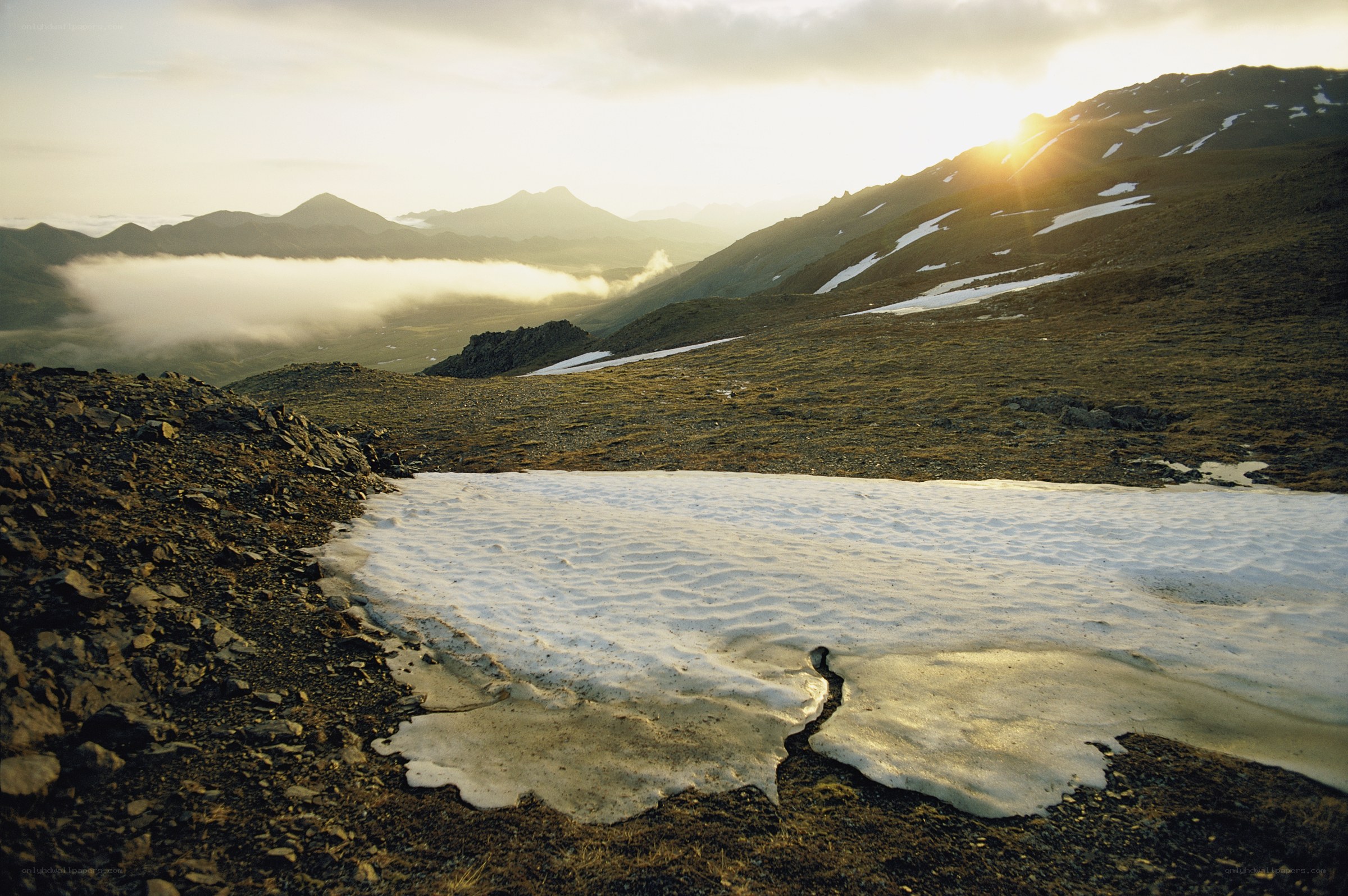 Sunset over snowy mountain slopes