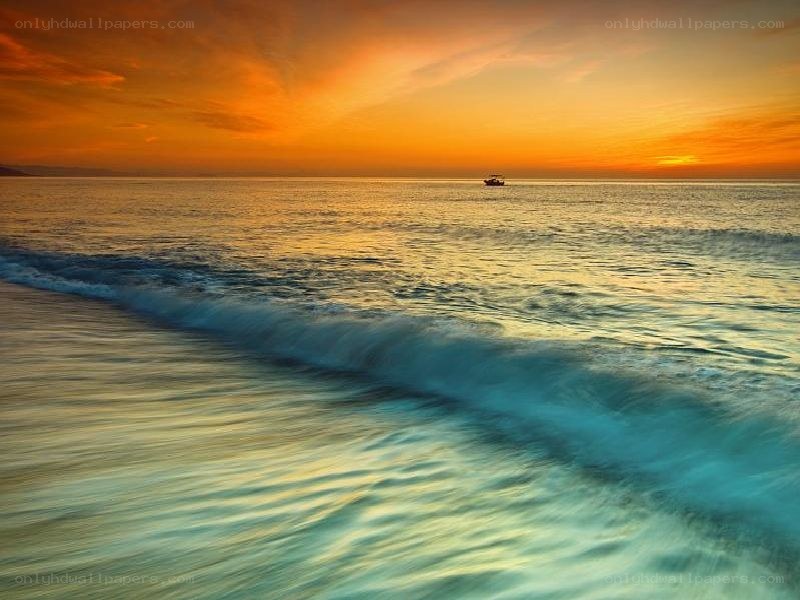 Sunset over the ocean with a boat