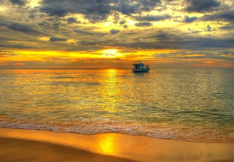 Sunset over the ocean with a boat
