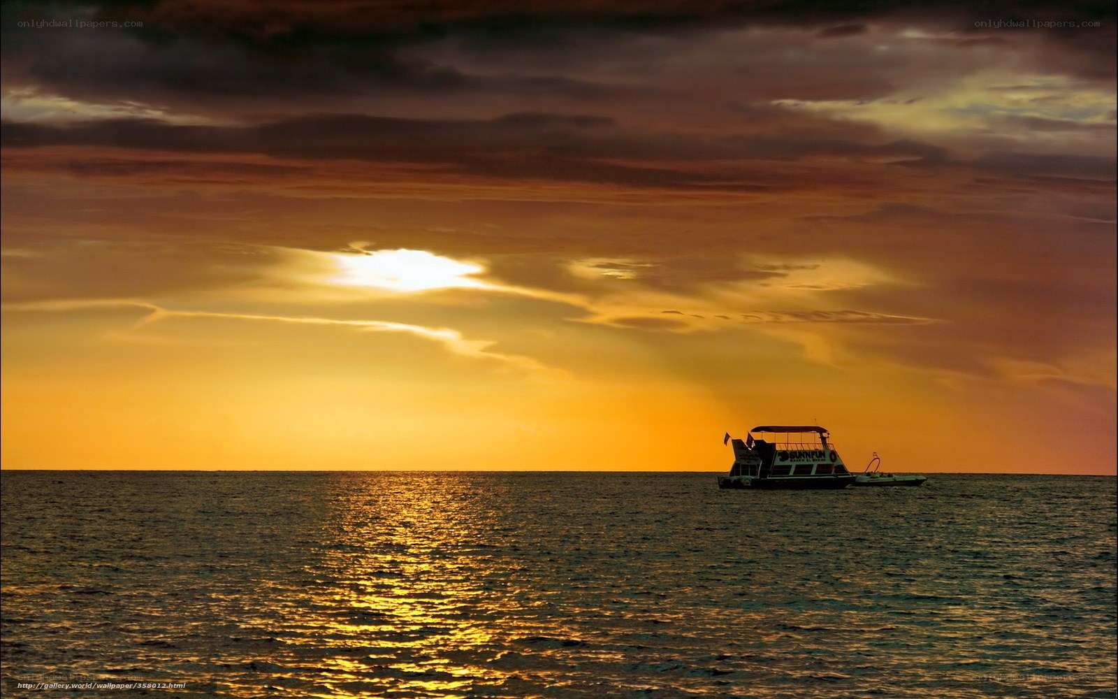 Sunset over the ocean with a boat