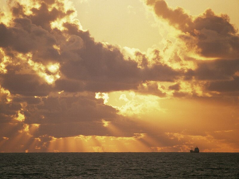 Sunset over the ocean with a ship