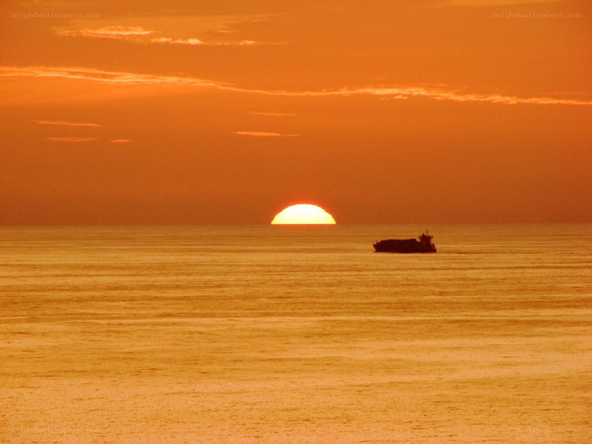 Sunset over the ocean with a ship