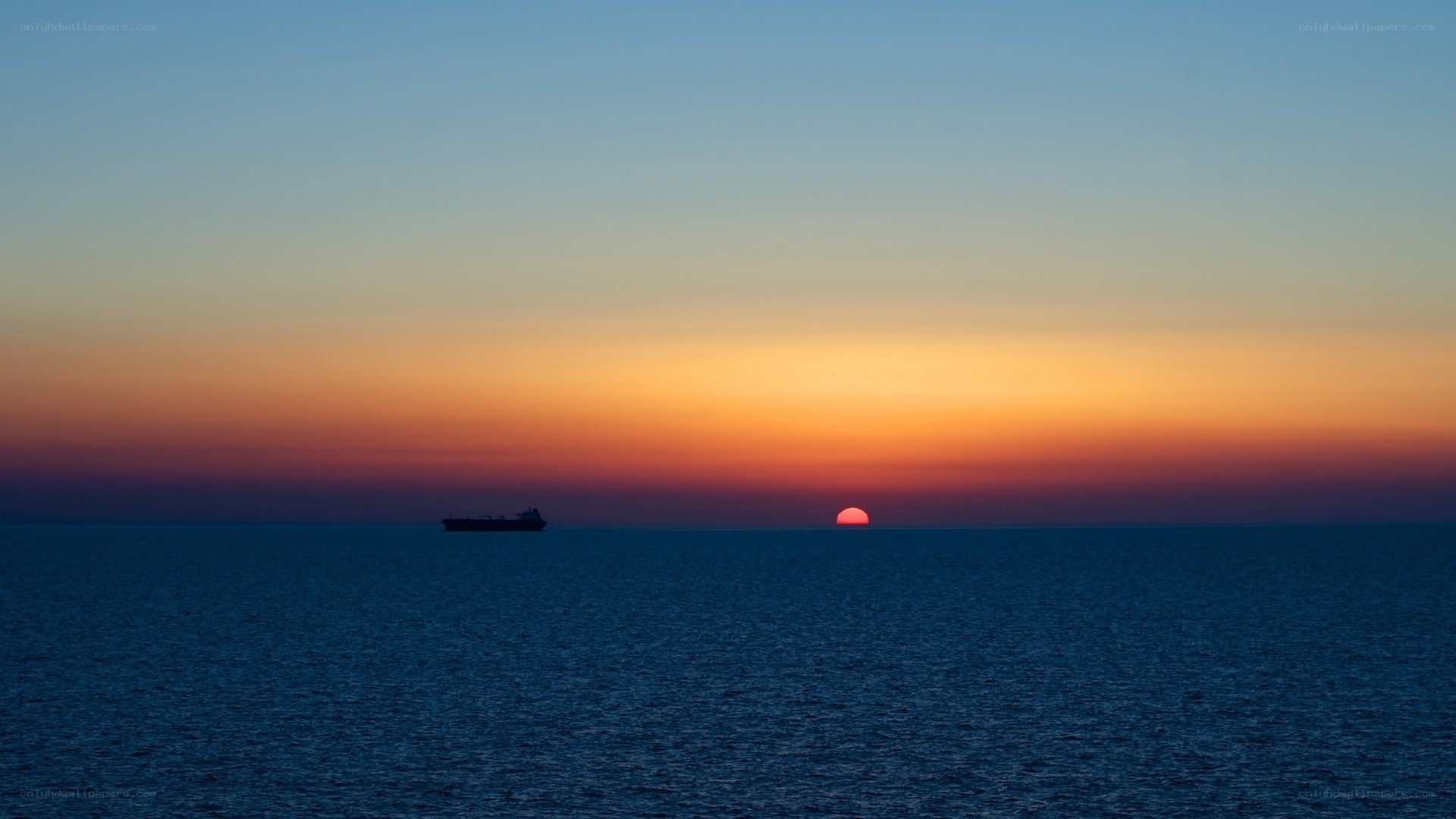 Sunset over the ocean with a ship
