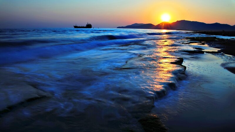Sunset over the ocean with a ship