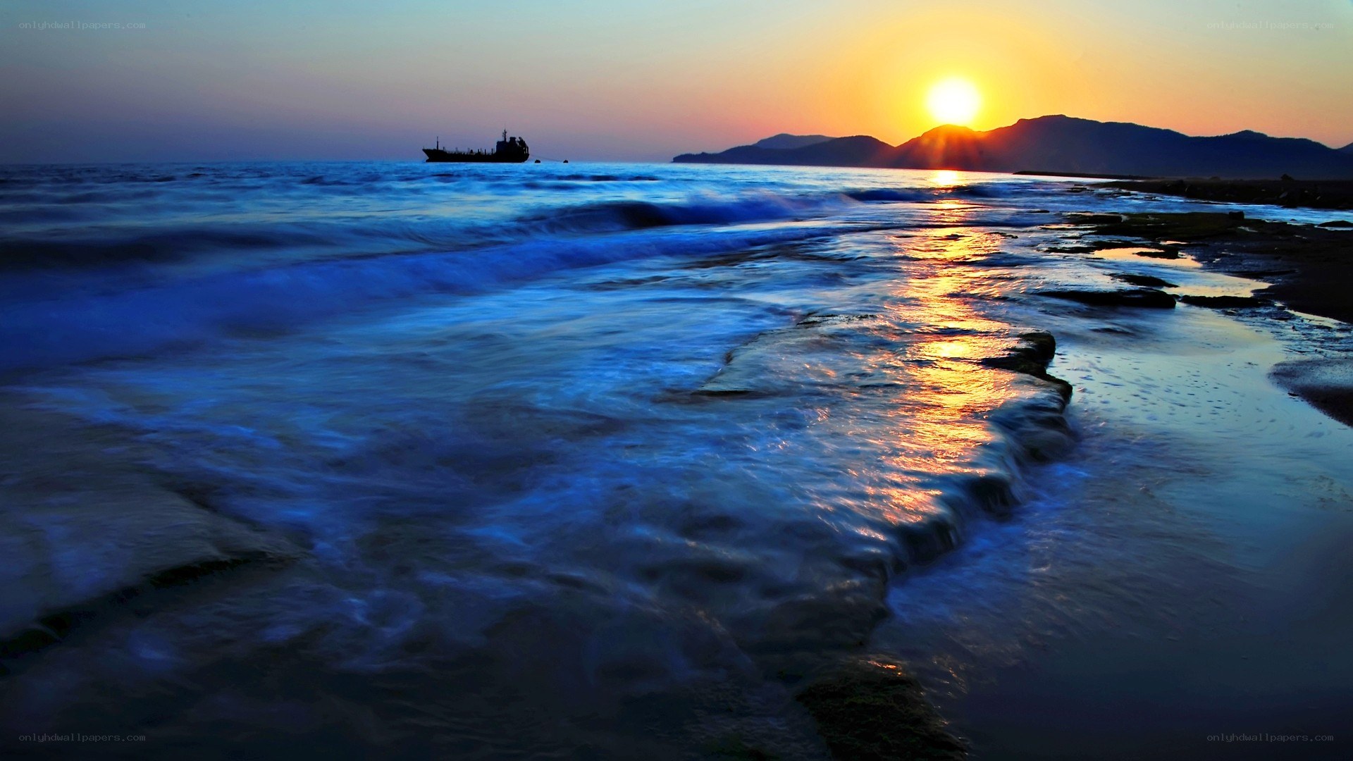 Sunset over the ocean with a ship
